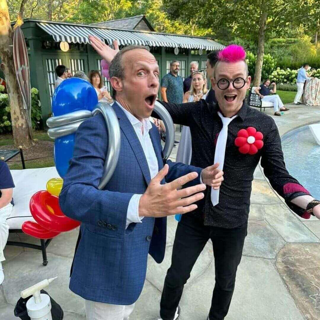 Dave Brenn with another performer ballon artist at lively outdoor outdoor party in new york city